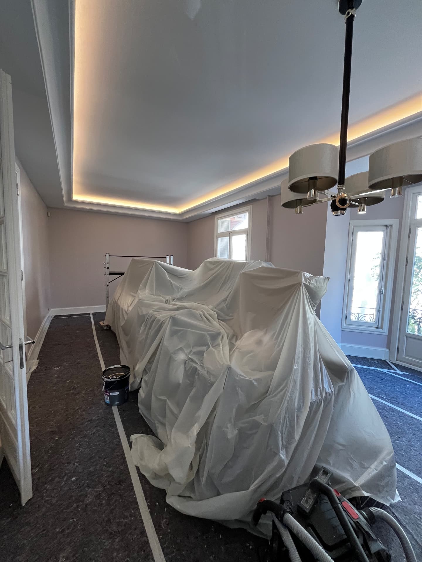 LUX RENOV Monaco — pièce de vie : corniche lumineuse et murs peints en rose poudré