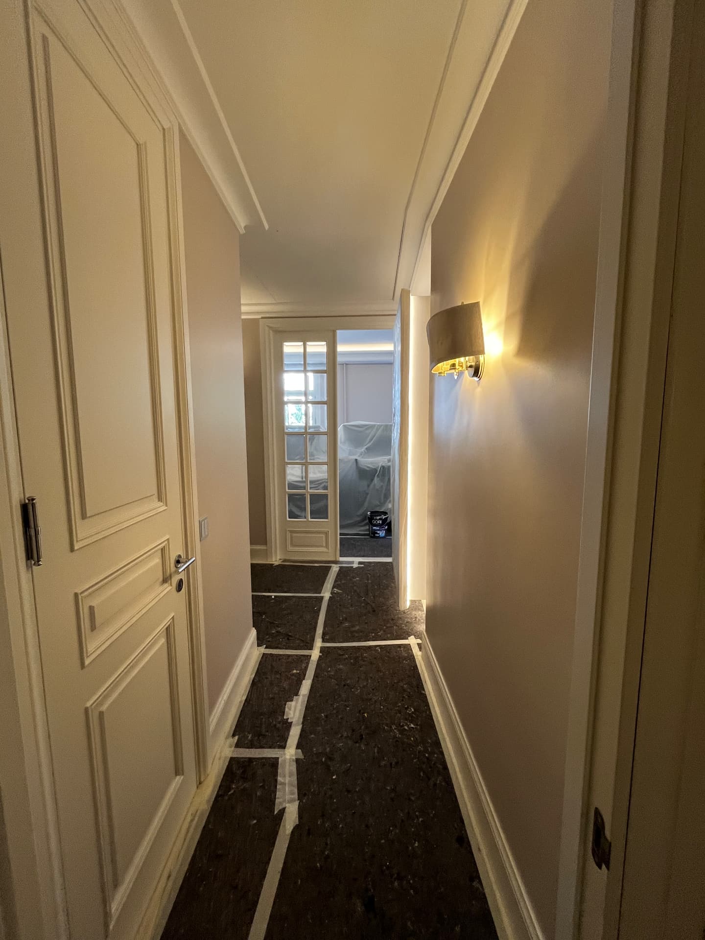 LUX RENOV Monaco — couloir fini : portes à moulures laquées et murs en teinte sable