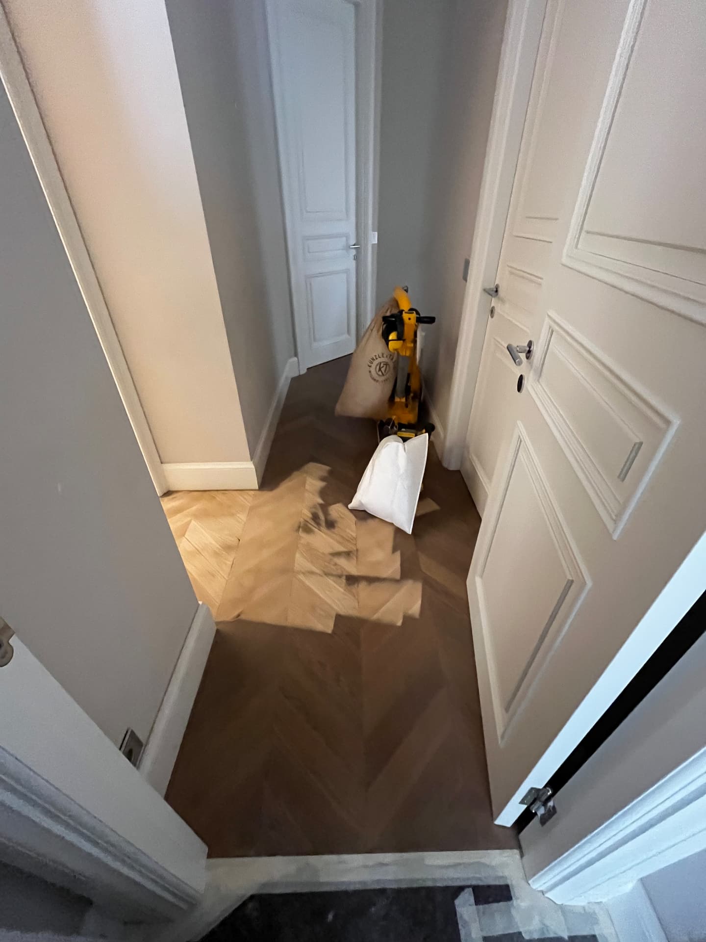 LUX RENOV Monaco — chantier en cours : ponçage du parquet point de Hongrie dans le couloir