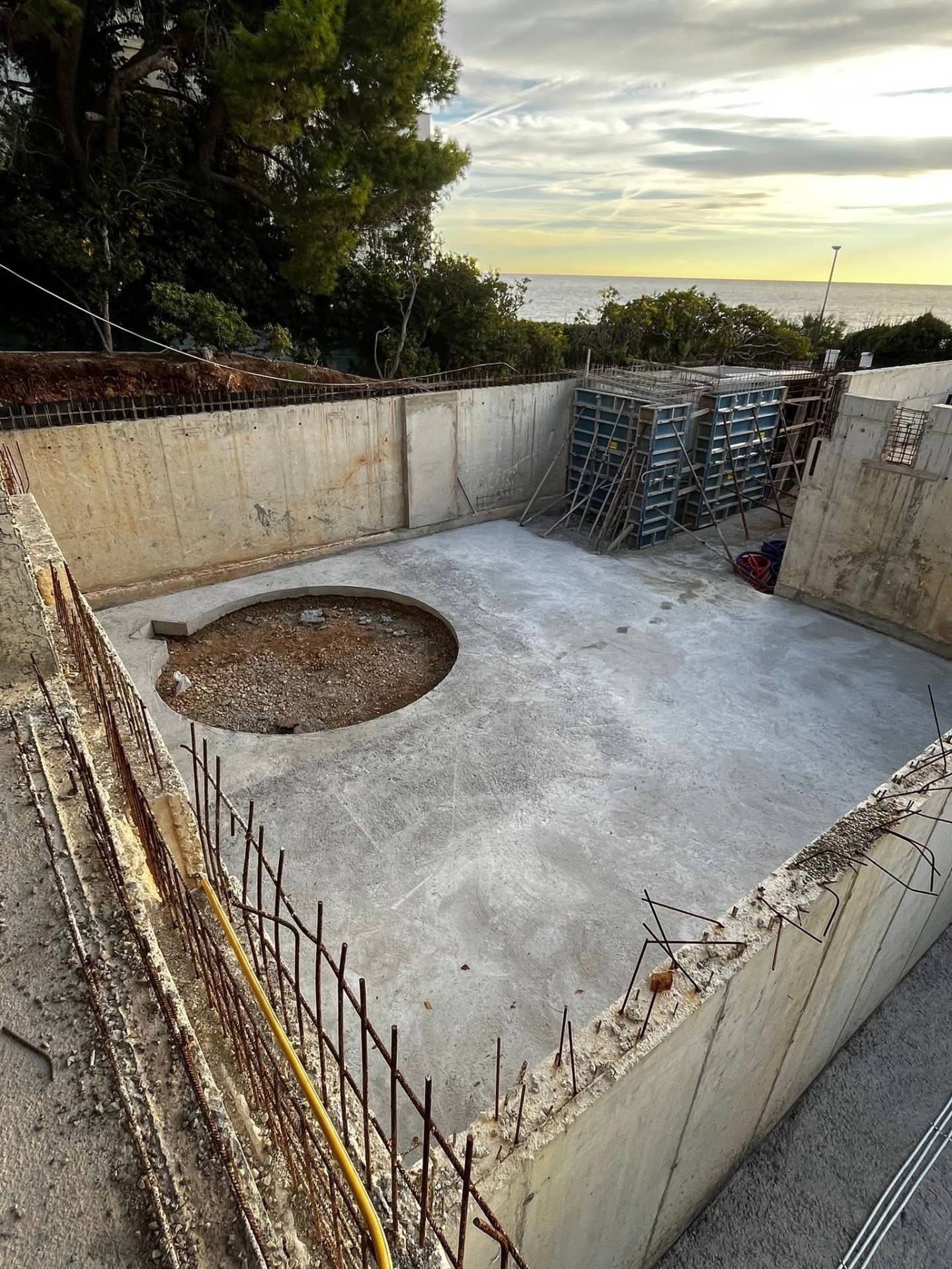 LUX RENOV — dalle béton finie avec réservation ronde, vue au coucher de soleil