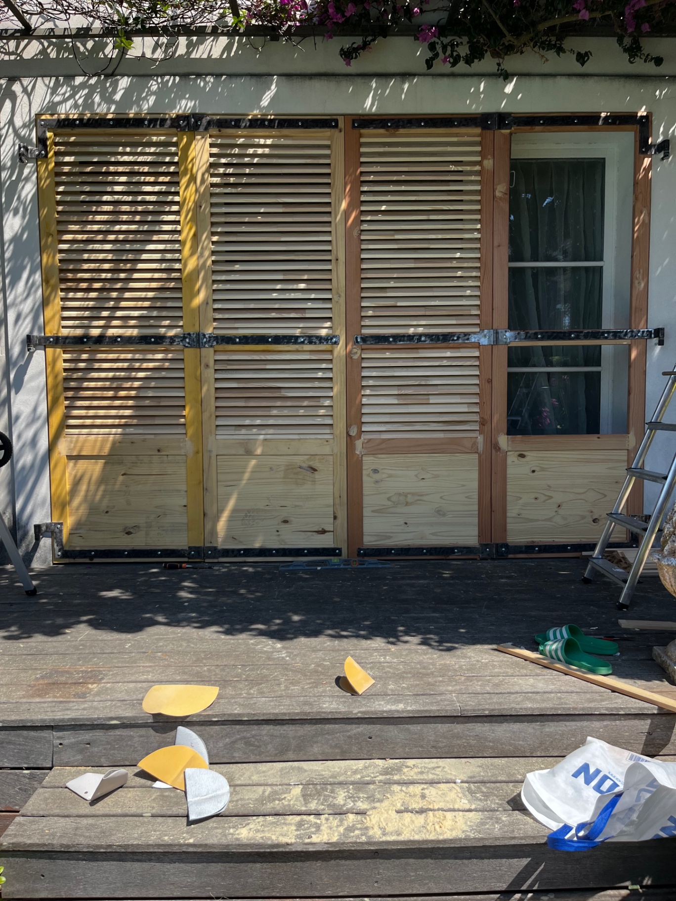 LUX RENOV — application de la teinte sur plusieurs volets bois en atelier extérieur