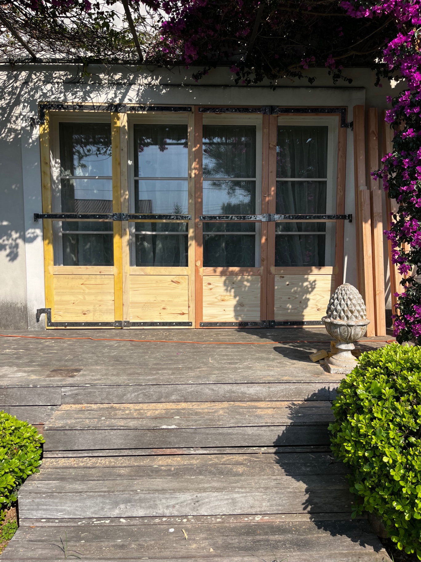 LUX RENOV — volets bois teintés installés en façade, résultat final sous la bougainvillée