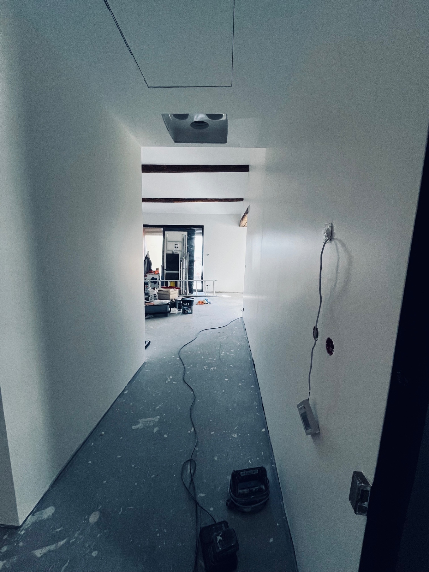 LUX RENOV — couloir long avec réservations techniques au plafond et finitions en cours