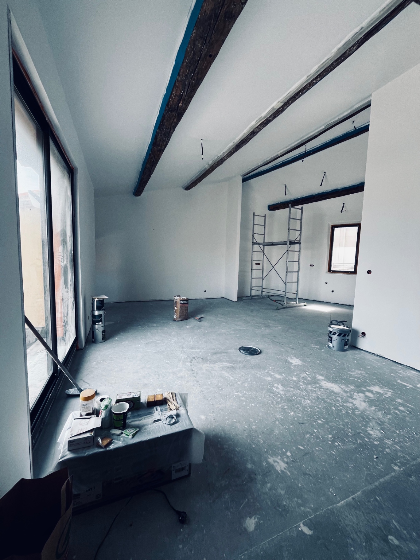 LUX RENOV — grand séjour avec poutres bois et baie vitrée donnant sur l'extérieur