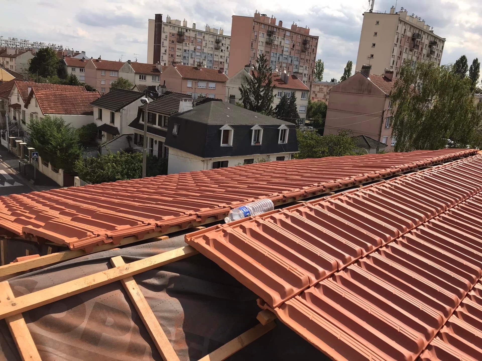 LUX RENOV — pose des tuiles terre cuite sur liteaunage neuf avec vue sur la ville