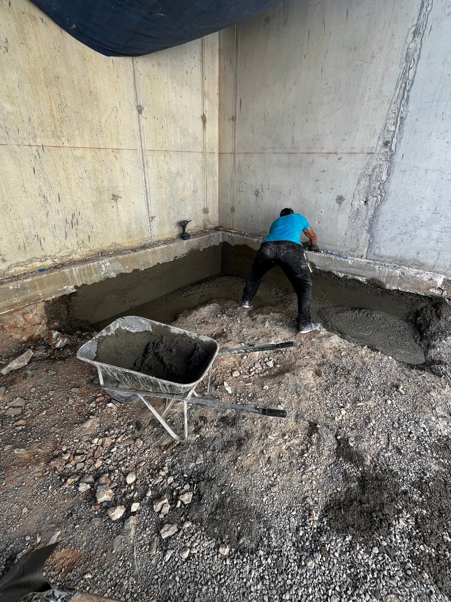 LUX RENOV — maçon en cours de renfort béton au pied du mur de soutènement