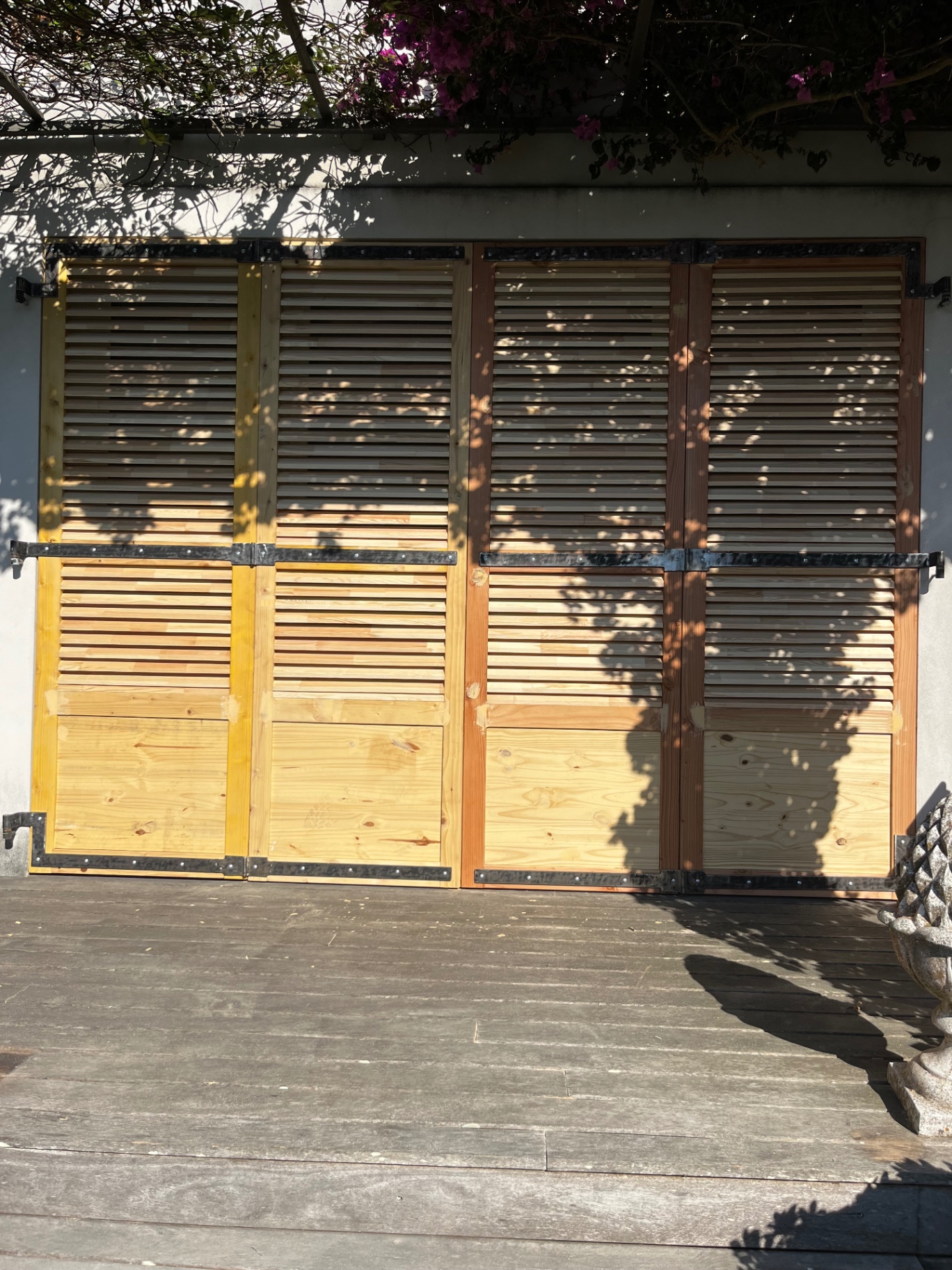 LUX RENOV — volets bois teintés alignés sur la terrasse, plusieurs nuances de finition