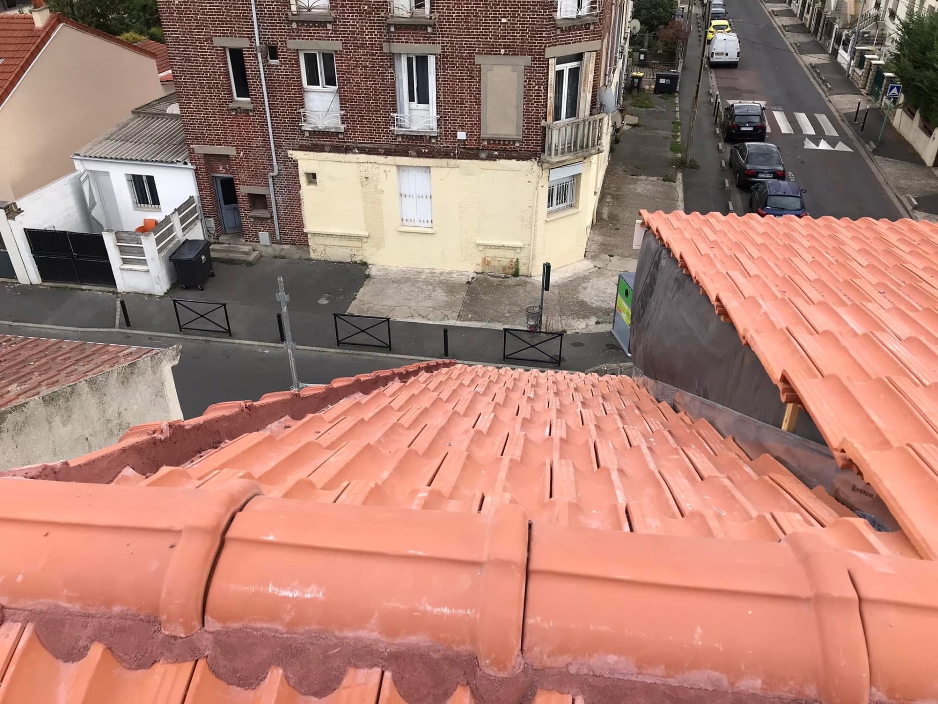 LUX RENOV — vue d'ensemble de la toiture neuve avec faîtière maçonnée surplombant la rue