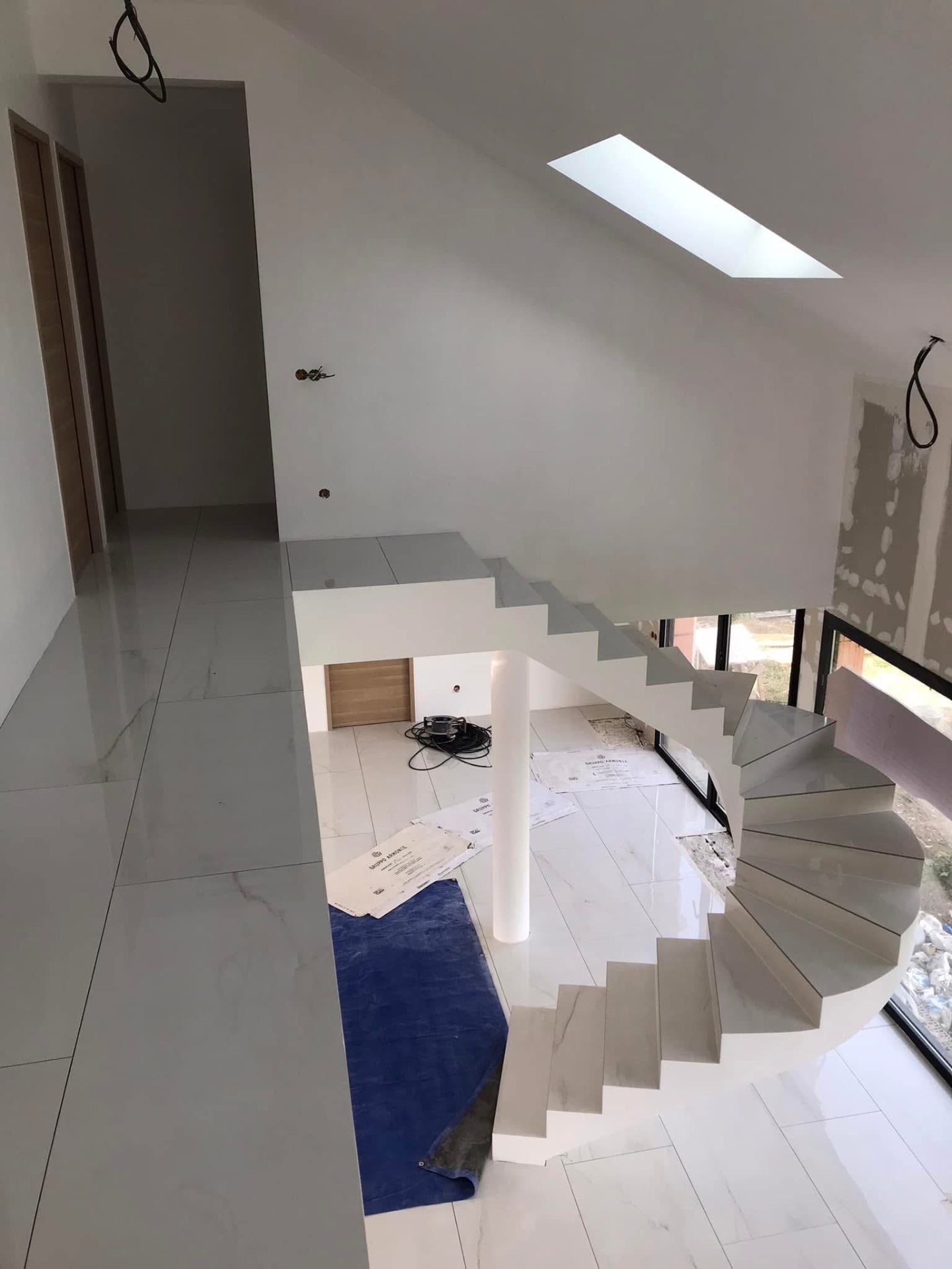 LUX RENOV — escalier hélicoïdal habillé marbre vu depuis l'étage