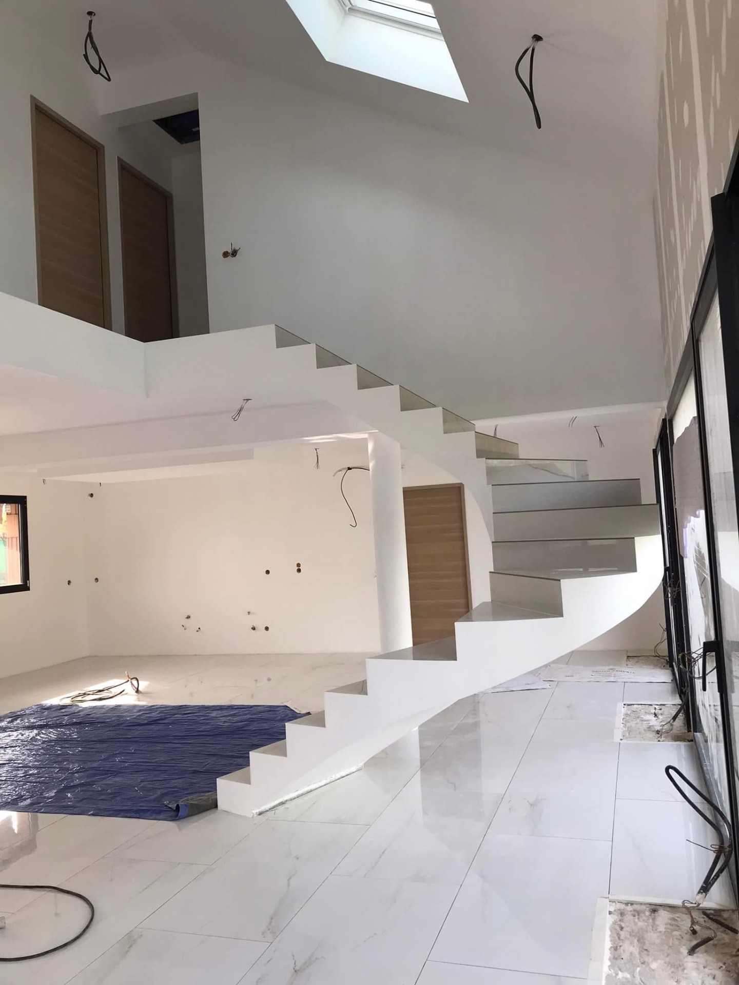 LUX RENOV — escalier hélicoïdal habillé blanc dans une pièce de vie lumineuse