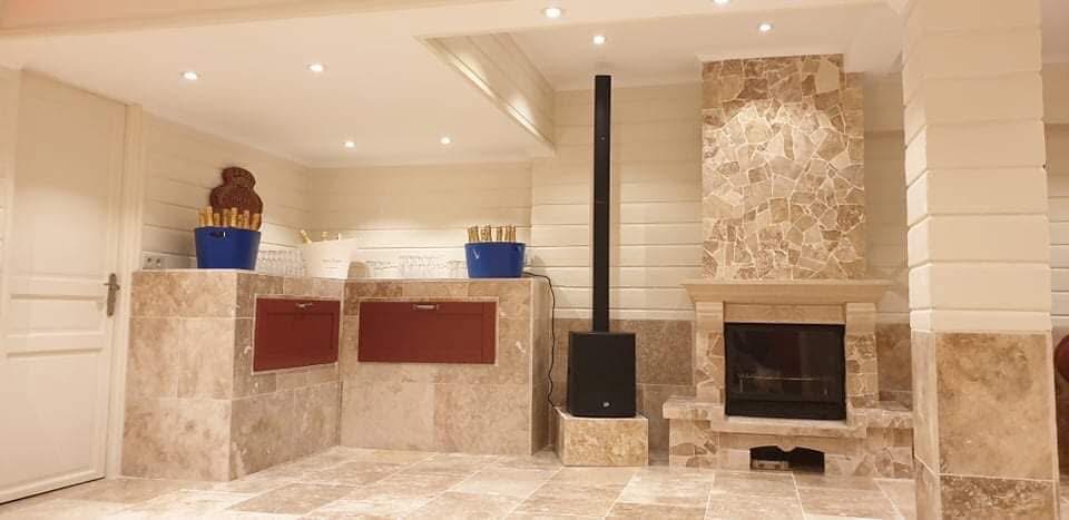 LUX RENOV — bar travertin avec poêle à bois et cheminée pierre adjacente