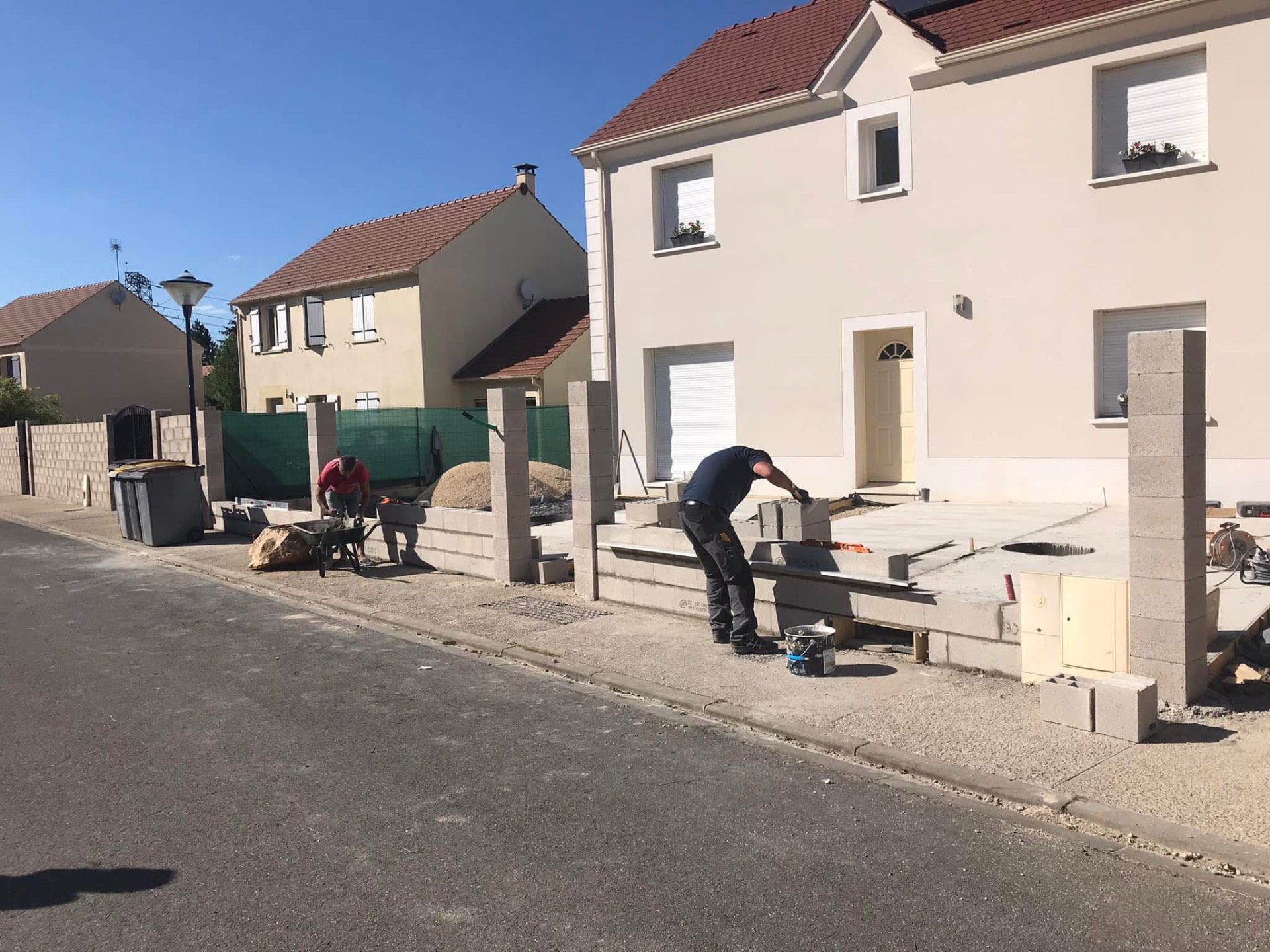 LUX RENOV — maçons en plein montage du muret de façade sur rue