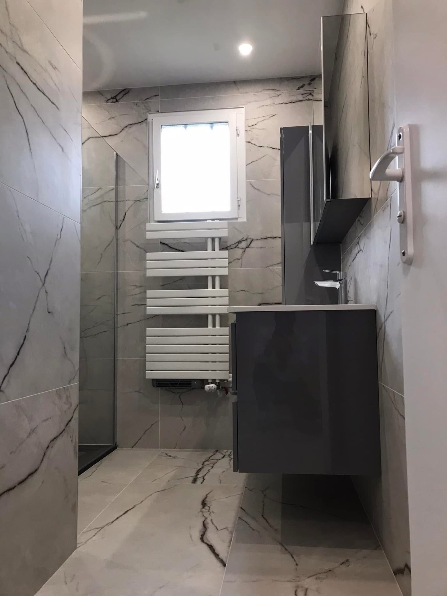 LUX RENOV — vue d'ensemble salle de bain marbre clair avec sèche-serviettes